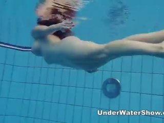 Redheaded honey swimming nude in the pool